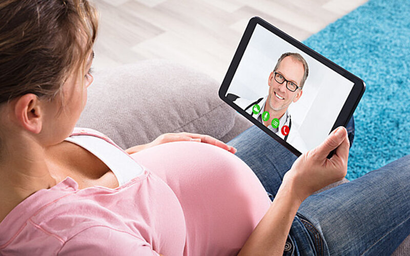 Schwangere hat eine Videosprechstunde mit einem Mitarbeiter von AOK-Clarimedis.