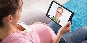 Schwangere hat eine Videosprechstunde mit einem Mitarbeiter von AOK-Clarimedis.