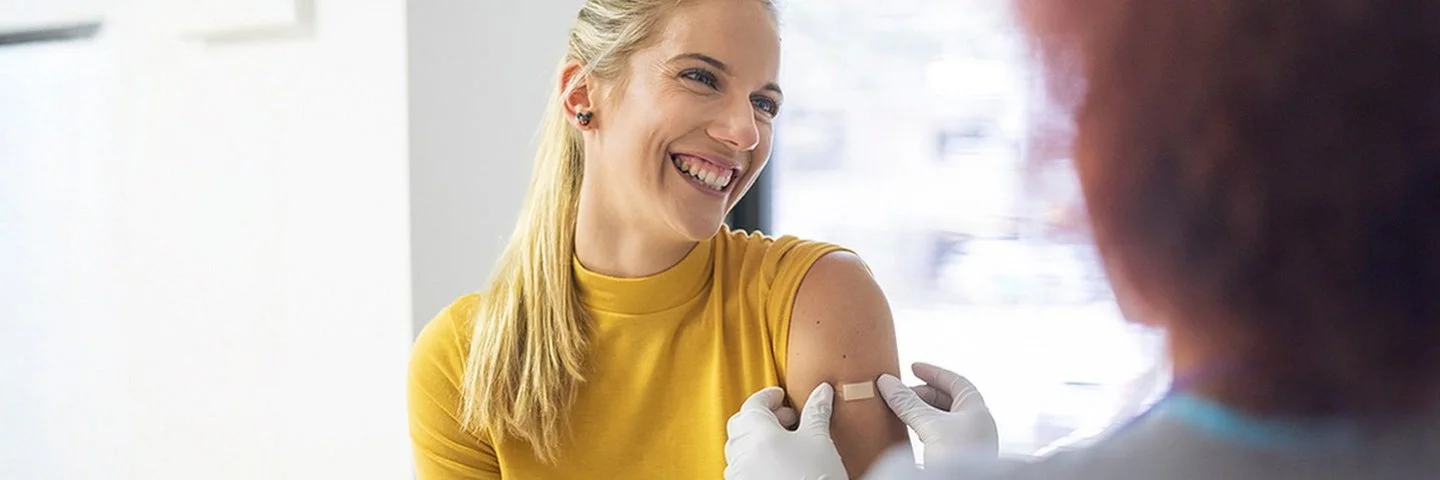 Eine junge Frau wird in den linken Oberarm geimpft.