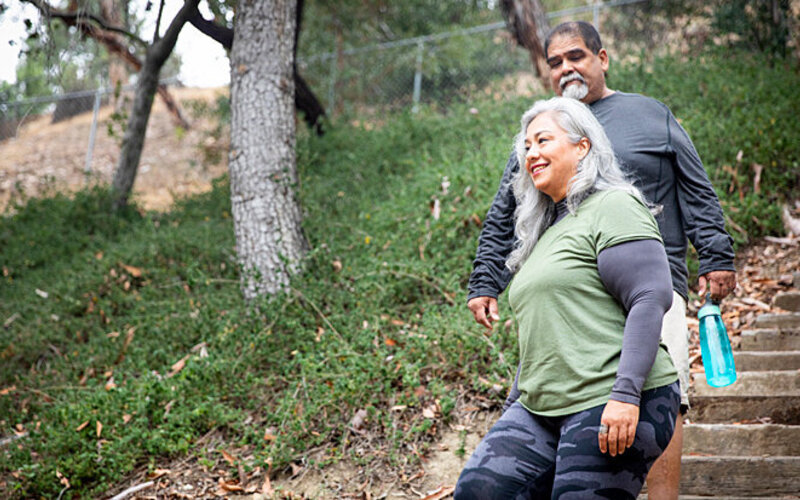 Zwei ältere Menschen gehen bewusst Treppen, um sich gesund und fit zu halten.