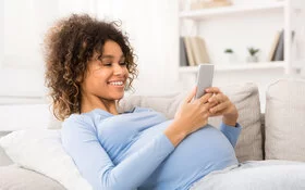 Eine Schwangere ruft bei einem Infotelefon an, um Fragen rund um die Schwangerschaft zu klären.
