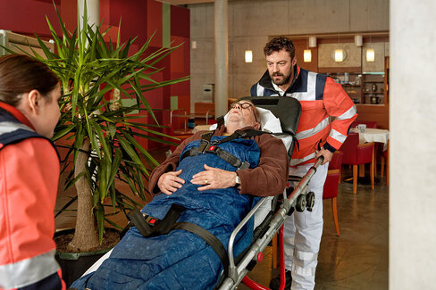 Mitarbeiter des Rettungsdienstes transportieren einen Patienten. Die AOK übernimmt bei Krankenhausbehandlungen einen Großteil der Kosten.