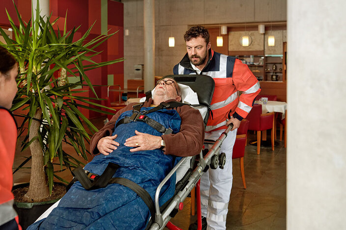 Mitarbeiter des Rettungsdienstes transportieren einen Patienten. Die AOK übernimmt bei Krankenhausbehandlungen einen Großteil der Kosten.