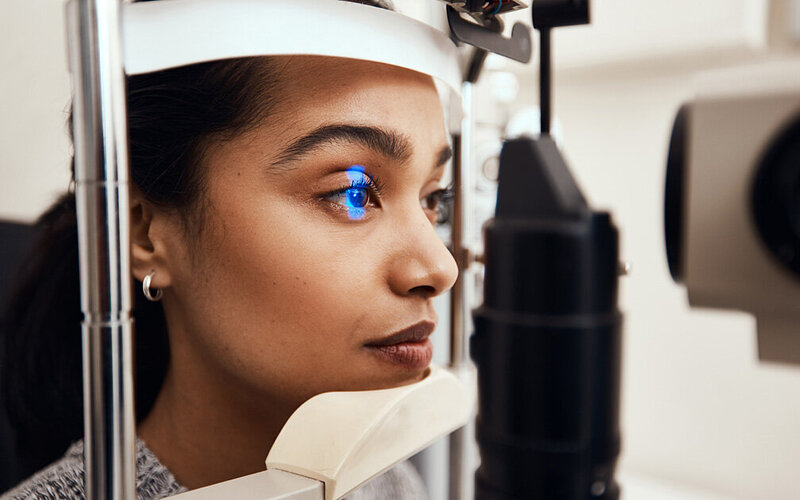 Bei einer jungen Frau mit Weitsichtigkeit wird mit einem augenärztlichen Spezialgerät die Brechkraft der Augenlinsen bestimmt.