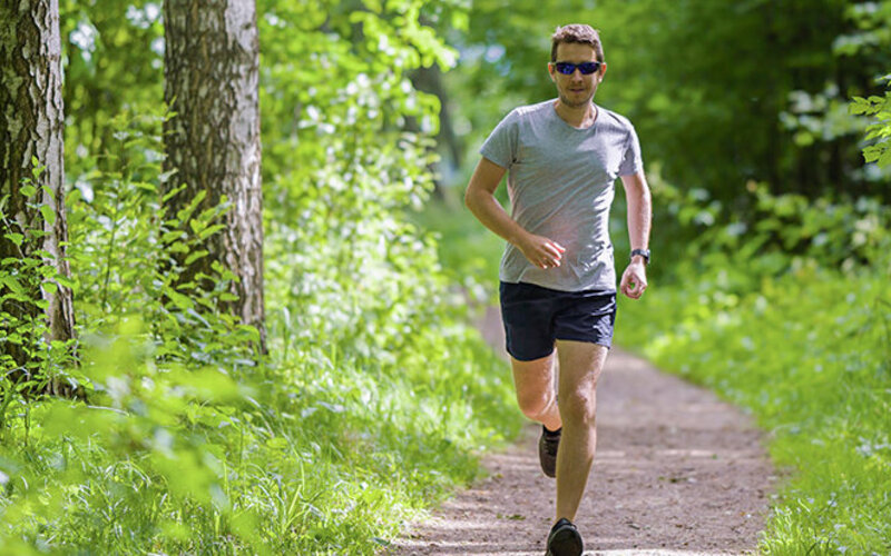 Mann beim Trailrunning im Wald