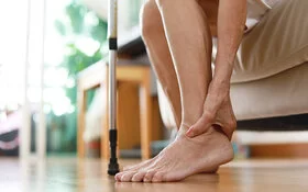 Frau mit Diabetes massiert ihre Füße.