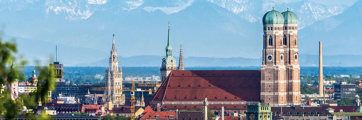 Es ist ein Panorama der Stadt München zu sehen, mit dem Dom "Zu unserer Lieben Frau" im Zentrum.