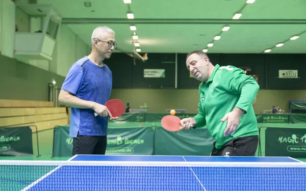 Zwei Tischtennisspieler in einer Sporthalle beim Ball schlagen. Foto: Jens Lehmkühler