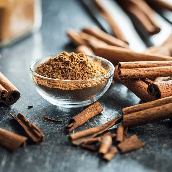 Gemahlener Zimt und Zimtrollen auf einem Tisch.