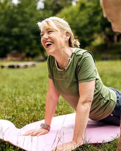 Ein sportlich gekleidetes Paar praktiziert Yoga im Park.