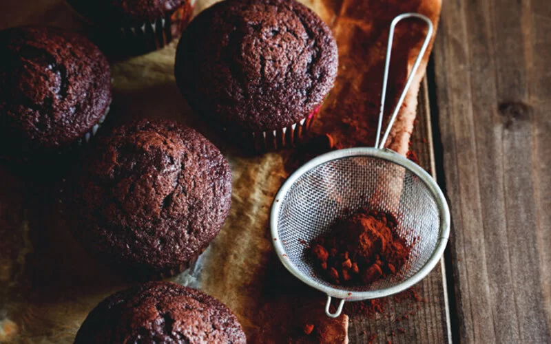 Muffins mit Öl statt Butter gebacken auf einem Holztisch angerichtet.