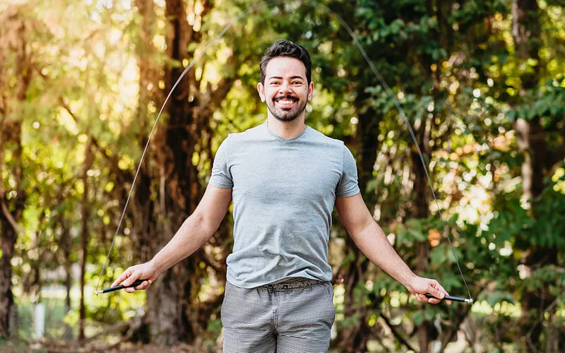 Ein Mann macht Seilspringen im Park – so geht Cardio Training.