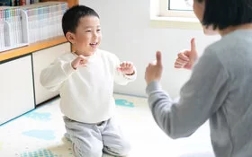 Mutter spielt mit ihrem kleinen Sohn Fingerspiele.