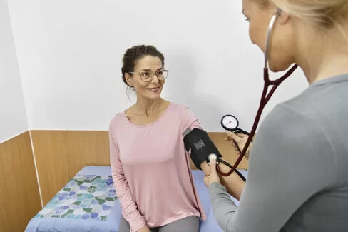 Eine Ärztin misst den Blutdruck einer Patientin. Mit regelmäßigen Gesundheits-Check-ups lassen sich Erkrankungen frühzeitig diagnostizieren.