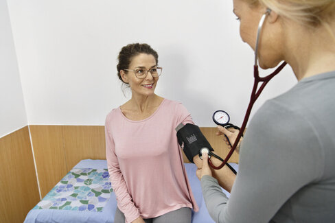 Eine Ärztin misst den Blutdruck einer Patientin. Mit regelmäßigen Gesundheits-Check-ups lassen sich Erkrankungen frühzeitig diagnostizieren.