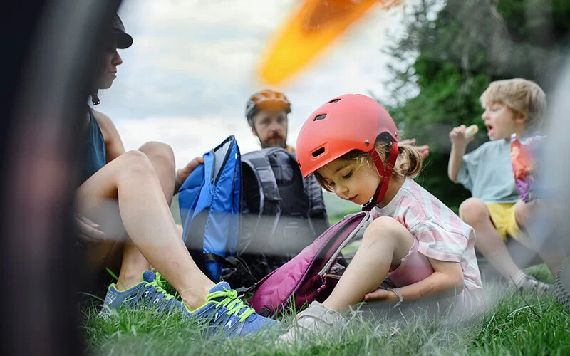 Familie macht ein Picknick nach der ersten Etappe ihrer gemeinsamen Radtour durch Hessen.