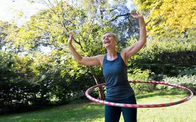 Eine Frau trainiert mit dem Hula-Hoop-Reifen.