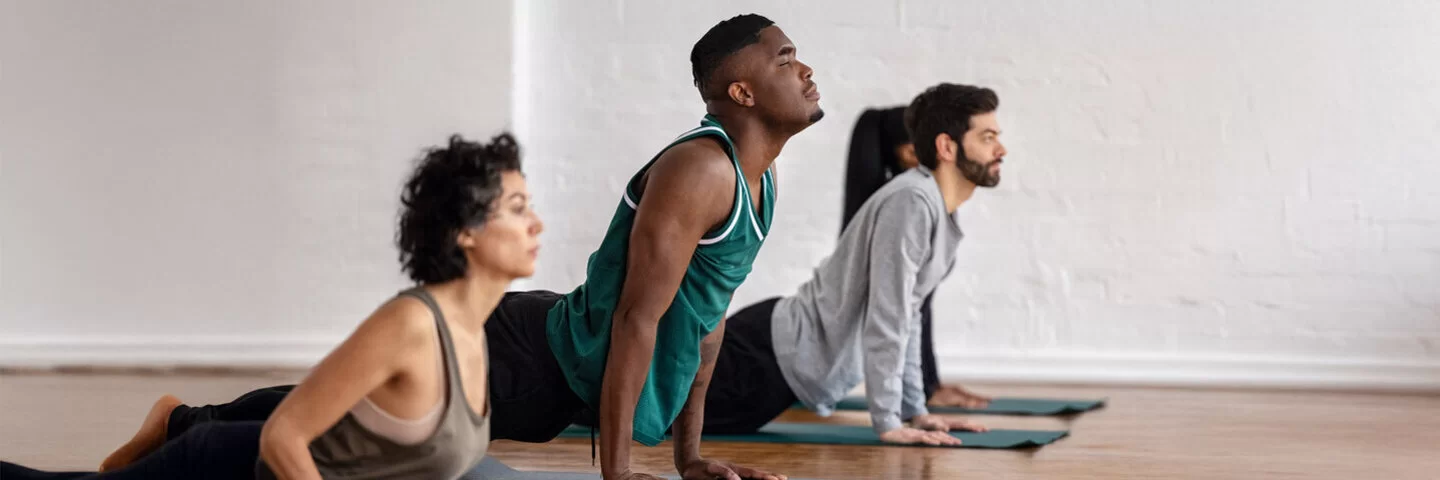 Gruppe von Menschen, die im Sportunterricht Yoga-Übungen praktizieren