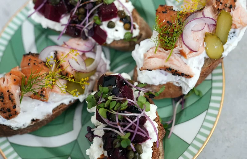 Lachs-Crostini und Rote-Bete-Crostini nach einem Rezept von Felicitas Then, angerichtet auf einem grün-weißem Teller, garniert mit Dill und Microgreens.