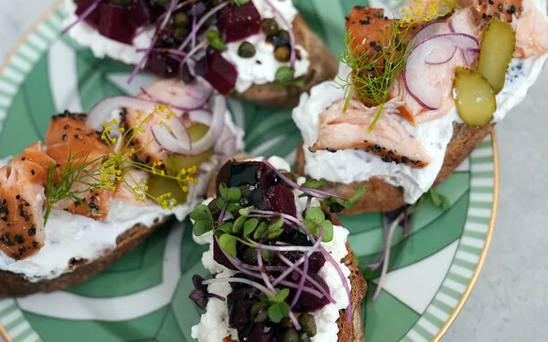 Lachs-Crostini und Rote-Bete-Crostini nach einem Rezept von Felicitas Then, angerichtet auf einem grün-weißem Teller, garniert mit Dill und Microgreens.