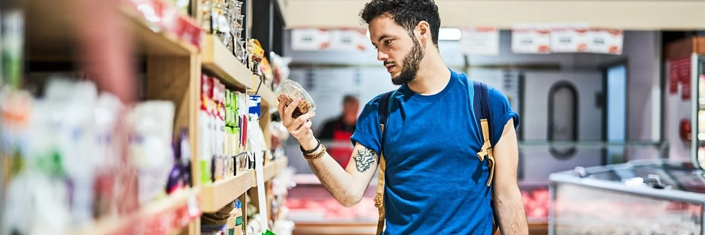 Kunde im Supermarkt checkt den Nutri-Score vom Produkt.