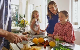 Familie, die zusammen ein gesundes Essen kocht.