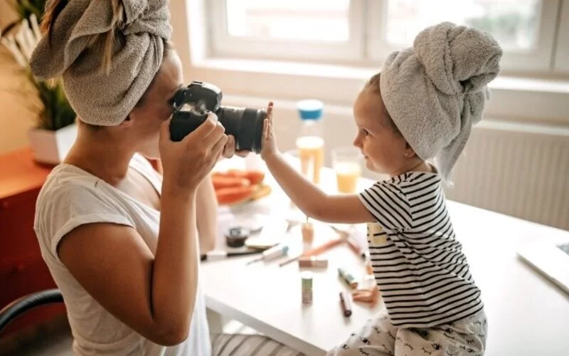 Eine Mutter macht ein Foto von ihrem Kind.