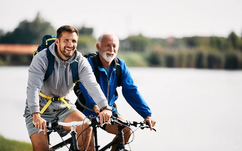 Vater und Sohn machen nach langer Pause wieder gemeinsam Sport und fahren Fahrrad.