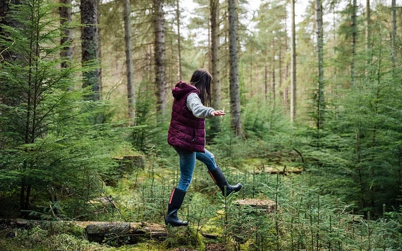 Mutige Frau geht allein durch den Wald.