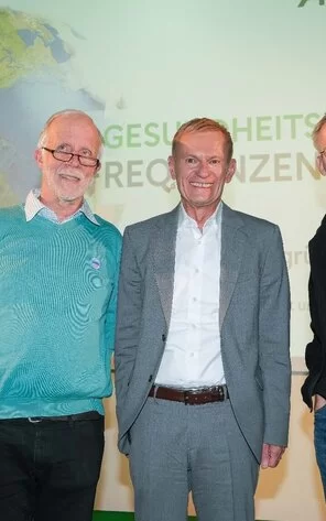 Auf dem Bild kann man drei Männer, in der Mitte Dr. Peter sehen.