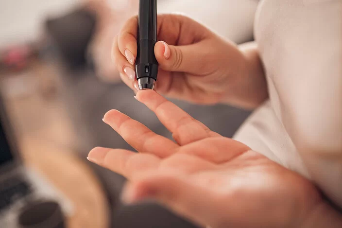 Eine Diabetes-Patientin sticht sich in den Finger.