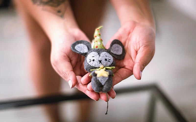 Hangemachtes Kuscheltier in Form einer kleinen Maus mit spitzem Hut.