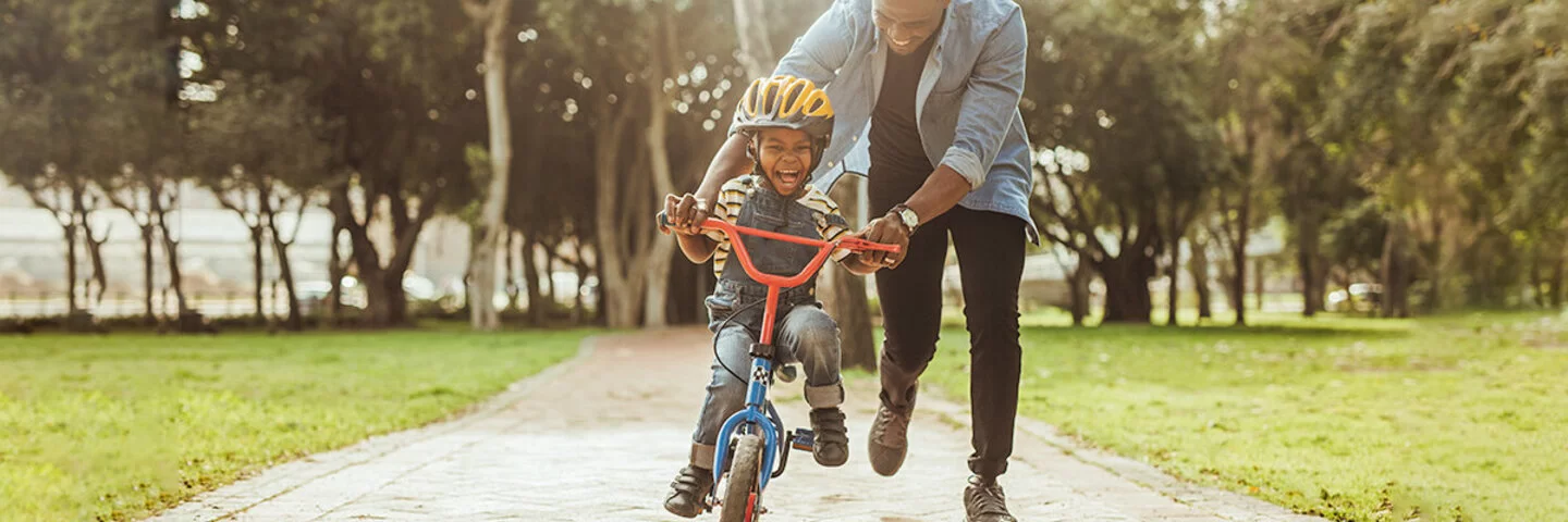 Vater bringt seinem Sohn das Fahrradfahren bei.