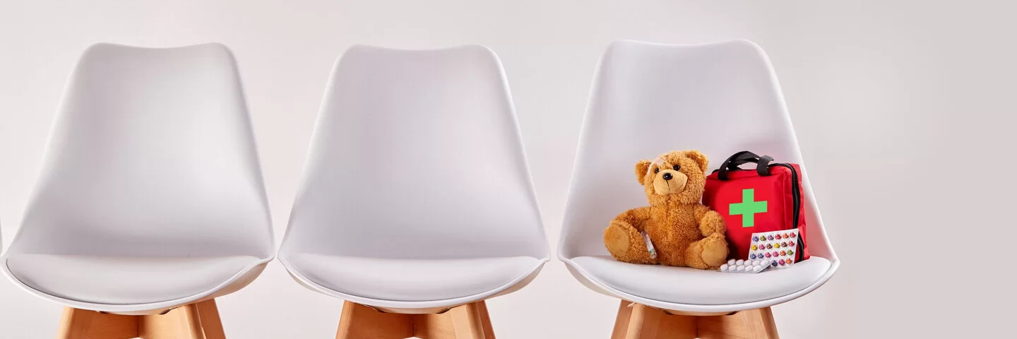 Teddy auf Stuhl im Wartezimmer
