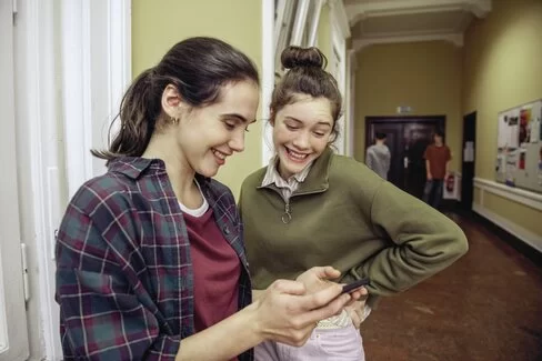 Zwei junge Frauen schauen auf ein Smartphone
