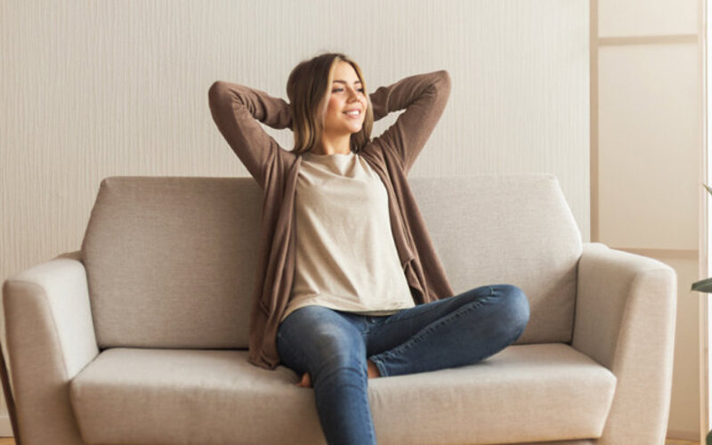 Frau entspannt sich allein auf dem Sofa, ist sie deshalb von Einsamkeit betroffen?