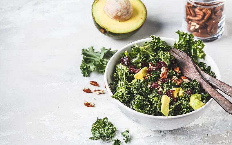 Grünkohl-Salat, angerichtet mit Avocado und Pekannüssen.