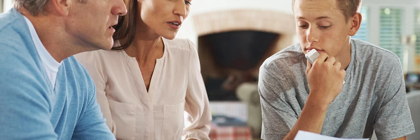 Vater und Mutter sprechen mit ihrem Sohn über seine schlechten Schulnoten.