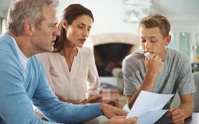 Vater und Mutter sprechen mit ihrem Sohn über seine schlechten Schulnoten.