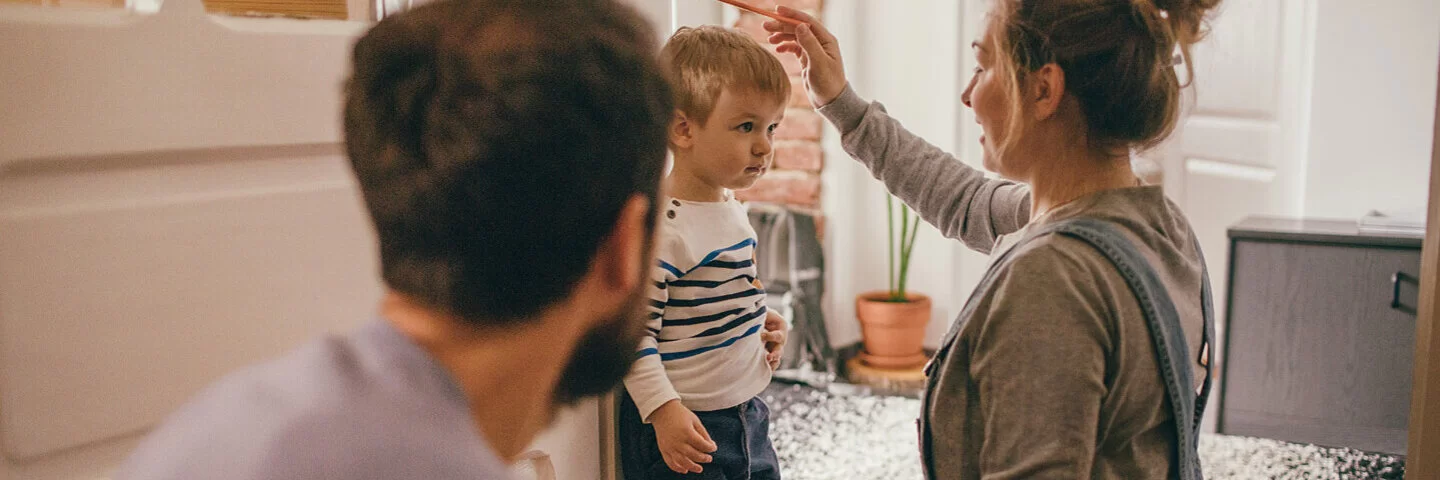 Eltern messen ihren Sohn und fragen sich: Wie lange wachsen Jungs? 