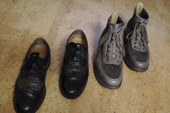 Zwei Paar Herrenschuhe stehen nebeneinander auf dem Fußboden.