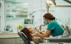 Eine Frau wird beim Zahnarzt gegen Pardodontitis behandelt.