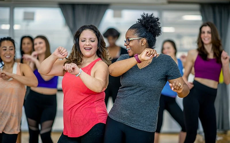 Eine Gruppe von Frauen tanzt zusammen in einem Übungsraum.