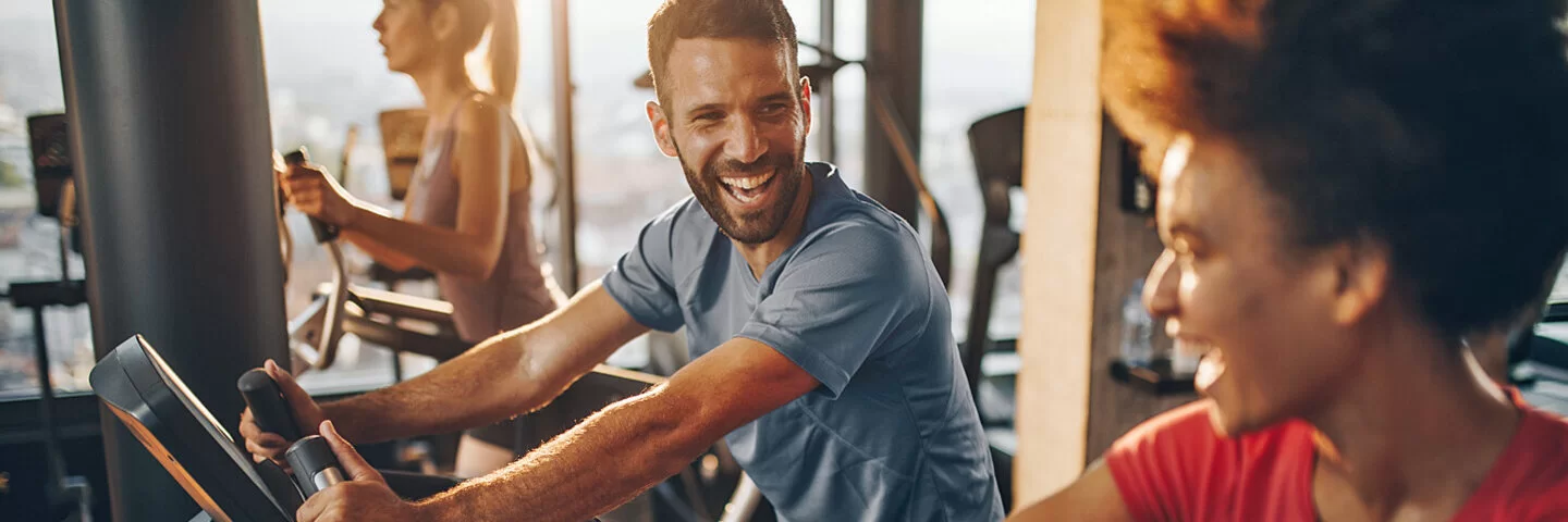 Mehrere Personen trainieren in einem Fitnessstudio.