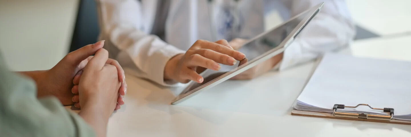 Ein Arzt hält einen Tablet-Computer in der Hand; eine Patientin sieht zu. Mehr zu den Nutzungsbedingungen der elektronischen Patientenakte können Sie hier lesen.
