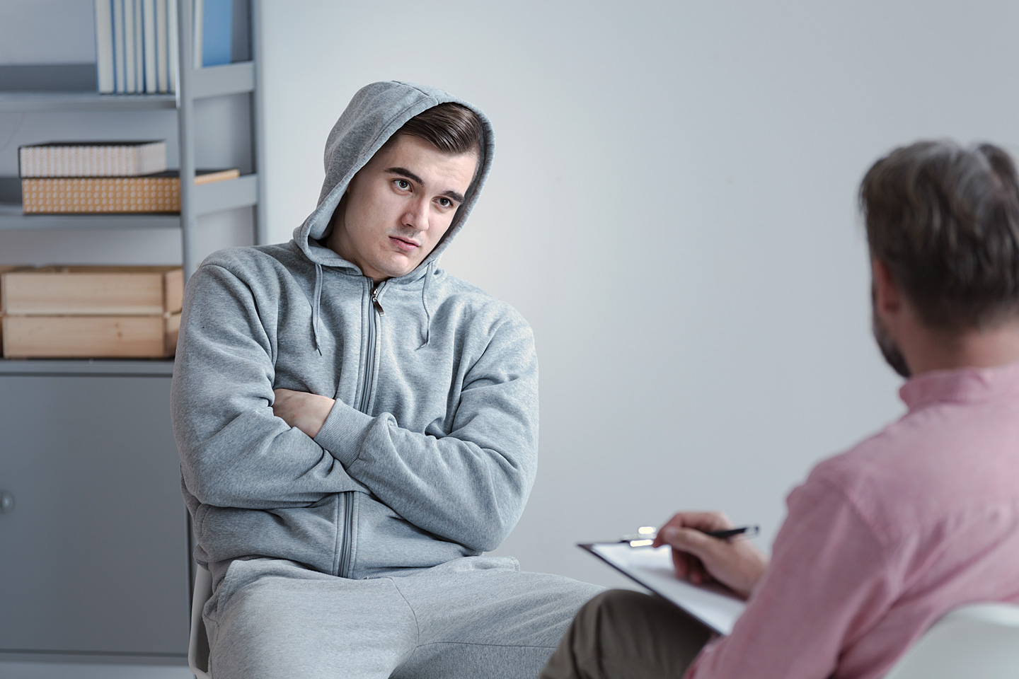 Jugendlicher mit einem Aggressionsproblem lässt sich wider Willen von einem Therapeuten beraten.