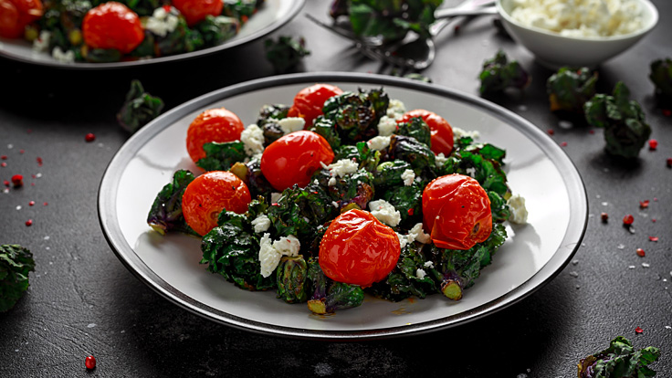 Ein selbst gemachter Kalettes-Salat mit Tomaten und Feta stehen auf dem Tisch.