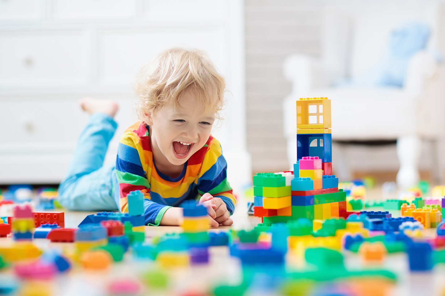 Ein kleiner Junge spielt mit Bauklötzen, denn Spielen ist gesund für Baby und Kleinkind.