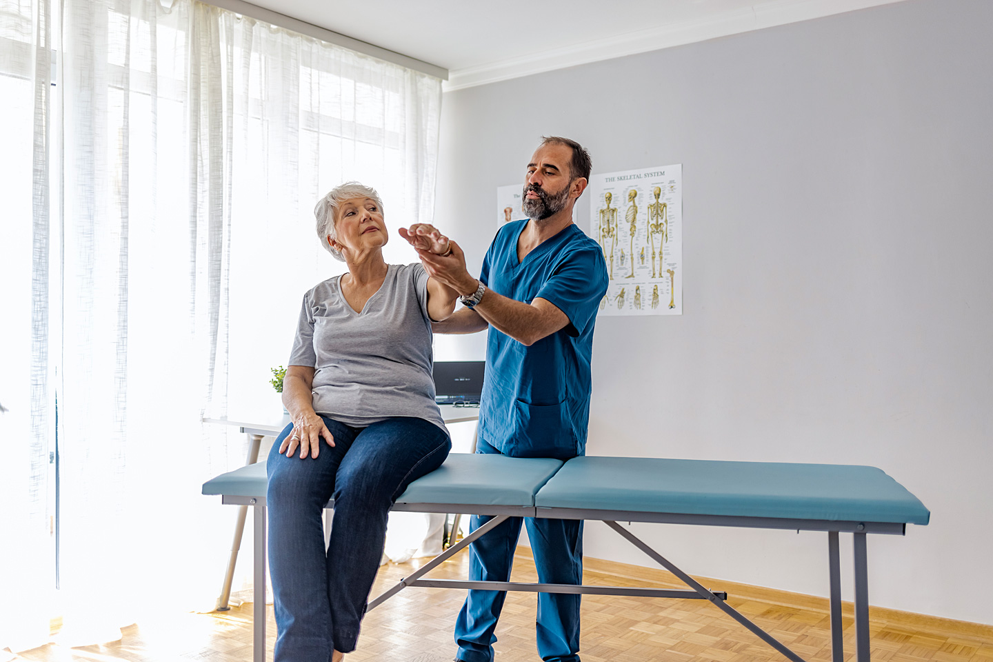 Physiotherapeut macht Übung mit einer Demenzerkrankten.