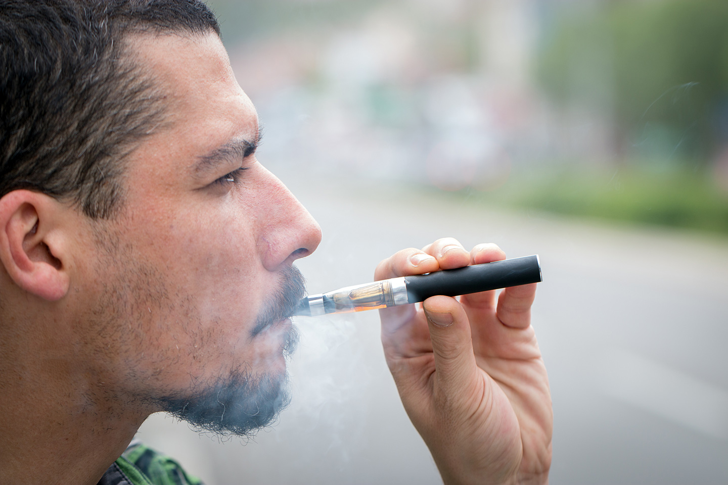 Ein junger Mann raucht eine E-Zigarette.